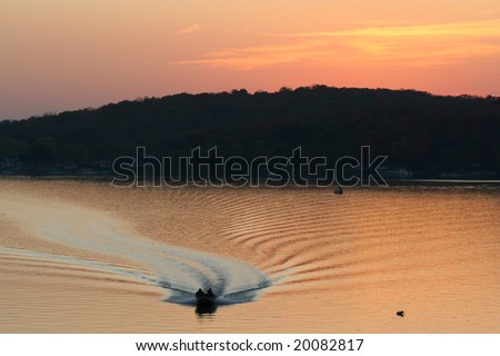 Power Boat coming back with a sunset background