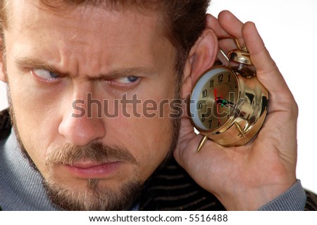 A man listening to an alarm clock sound
