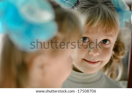 The little girl looks in the mirror