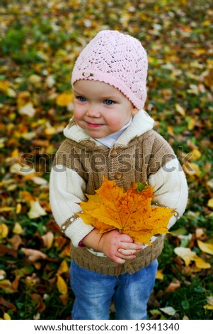 An image of nice baby in leaves in autumn park