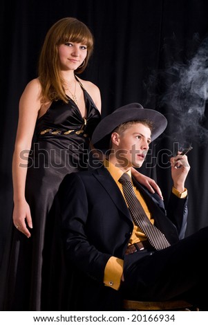 An image of woman and man with cigar in dark room