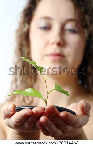 An image of a woman looking at plant and stones in her hands