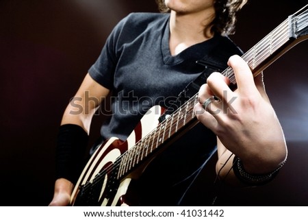An image of a man playing electrical guitar.