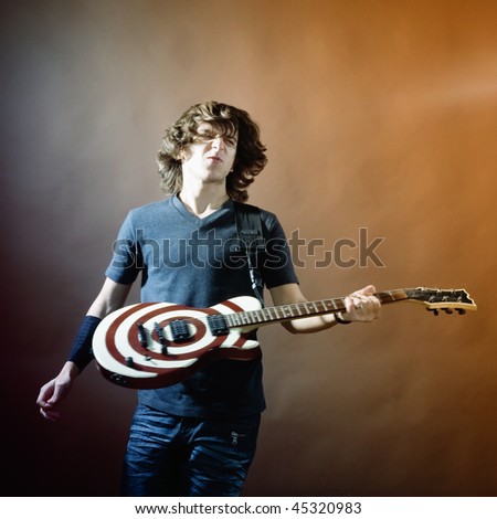 An image of a young man with guitar on black background