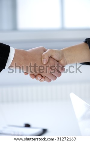 Handshake to seal a deal  - with bright office in the background