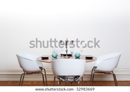 Modern dining room with a round table and  white chairs and background.