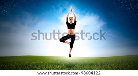 Meditating woman levitate over green field in nature.