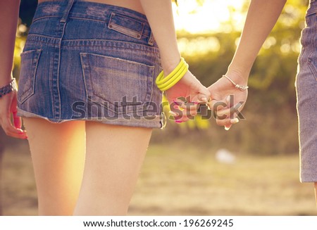 Two woman holding their hands