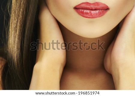 Close-up shot of sexy woman lips with red lipstick and red manicure