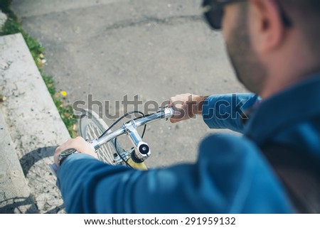 hipster young man on bike in the city park