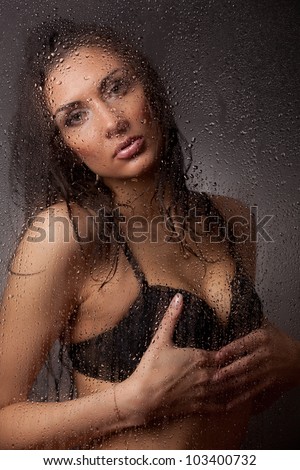 Girl in a black bra and jeans for wet glass.