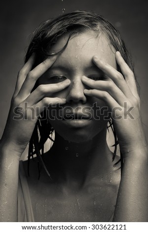 Portrait of a girl, which poured water on gray background.