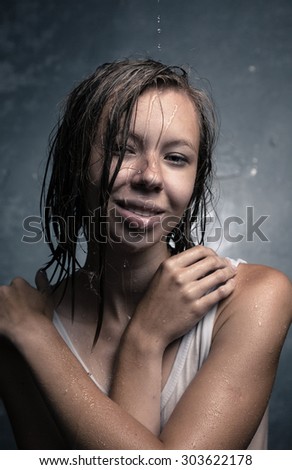 Portrait of a girl, which poured water on gray background.