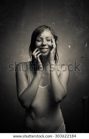 Wet girl in wet t-shirt on a gray background.