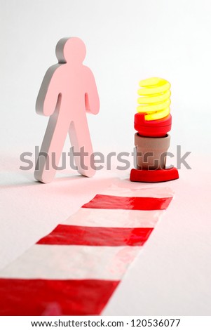 Wooden figure standing at chevron and warning light.  Safety in working place.