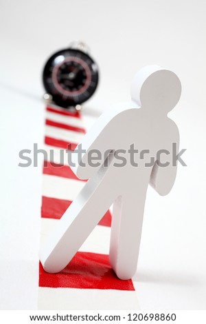 Danger of long working hours.  Male figure standing on chevron in front of clock
