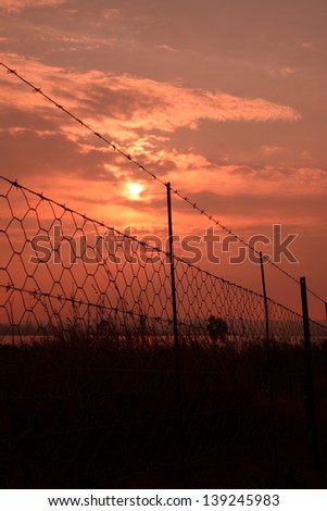 Sunrise with barbed wire fence