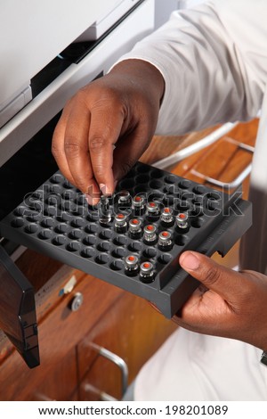 Scientist placing samples into a tray for testing.