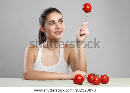 smiling woman with a tomato on a fork