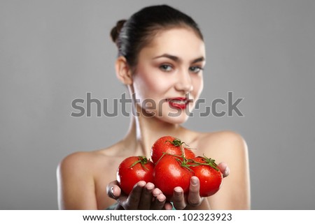smiling woman with a tomatos in  hand