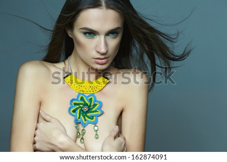 brunette girl with long hair in a luxurious designer decorations in the studio