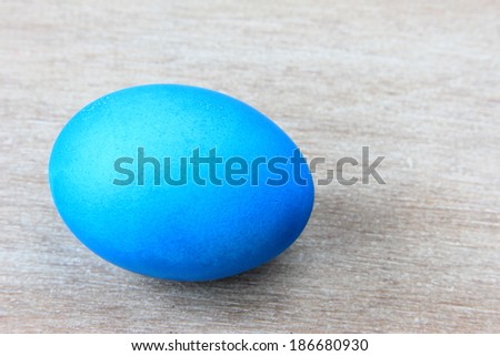 One colored blue Easter egg on gray wooden background