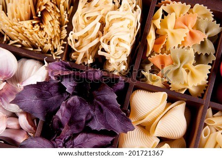 Pasta in a wooden box with basil and garlic