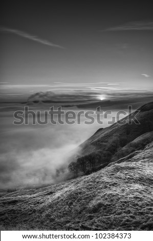 The sun just breaks the horizon over the Hope Valley in the Peak District, illuminating the top of the cloud inversion that fills the valley from the foot of Mam Tor to the far side of Grindleford.