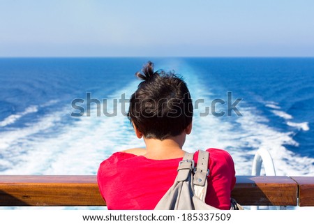 girl looks at a ship on the horizon