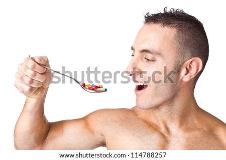 an handsome man taking a spoon full of pills - stock photo