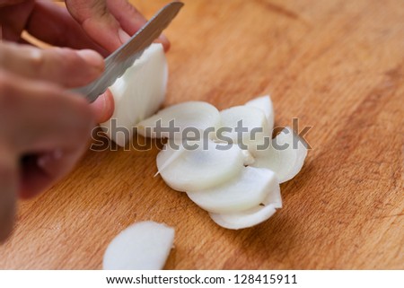 cutting onions on a wooden chopping board