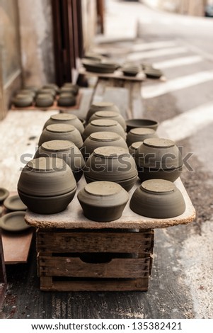some crockery arranged on the street in a typical italian artisan shop