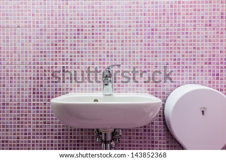 a clean white sink in a bathroon with pink tiled walls