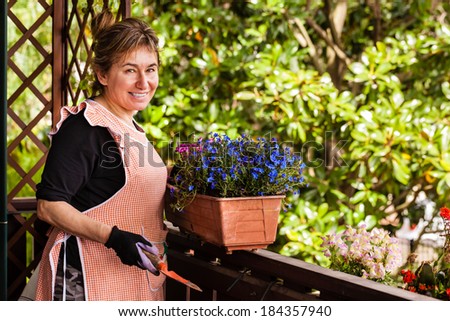 a cheerful old lady gardening in her terrace