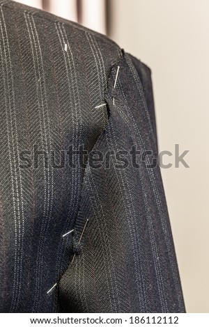 detail of an unfinished suit in a tailor shop