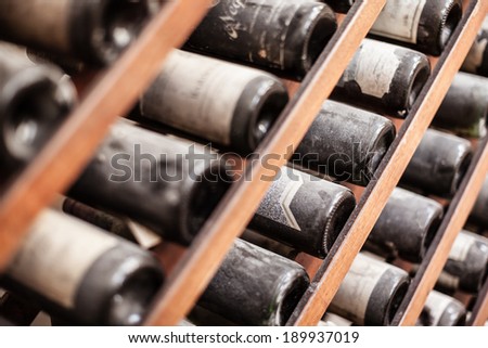 a lot of very old dusty wine bottles in an italian cellar