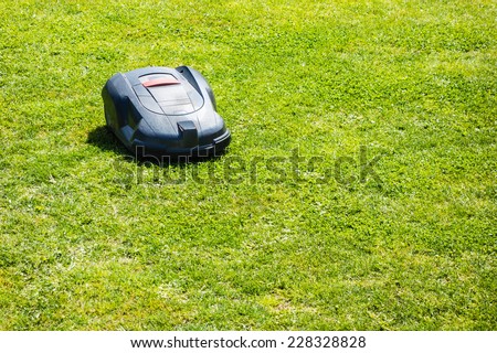 a robotic lawn mower working on a green grass field