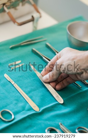 the hands of a surgeon using a metal scalpel