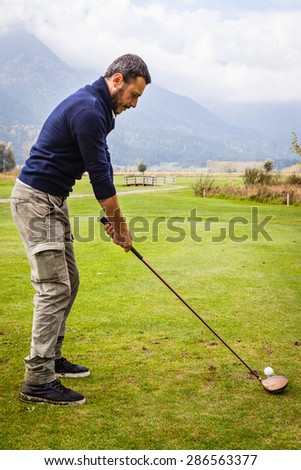 a golf player making a swing on a vibrant beautiful golf course