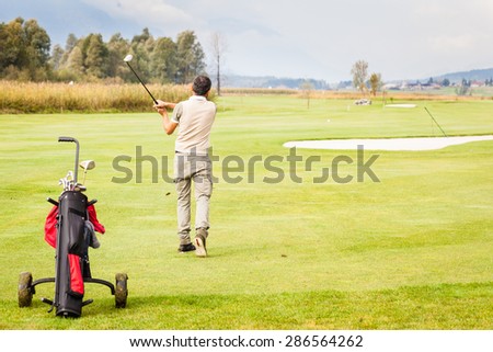 a golf player making a swing on a vibrant beautiful golf course