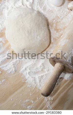Overhead shot of dough and flour ona table with rolling-pin