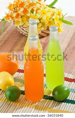 Overhead shot of cold drinks with fruits around them on wooden table