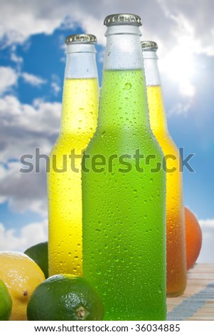 Close up shot of three bottles with tropical drink on wooden table