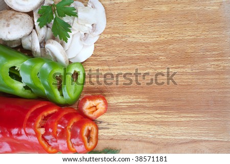 Sliced fresh veggies on bread board with empty space for text