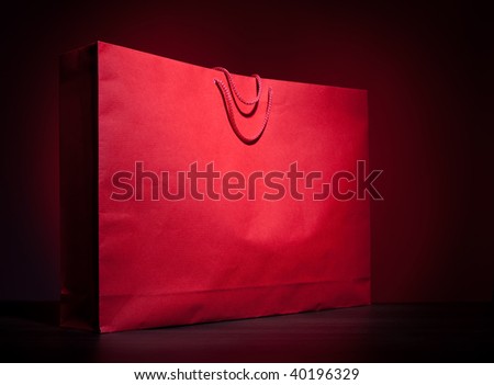 Big red shopping paper bag on dark red background