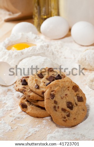 Stack of cookies on table top with flour and raw eggs