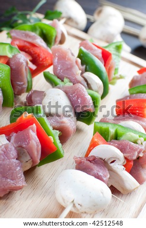 Close up of meat sticks of pork meat bell red and green peppers and fresh mushrooms