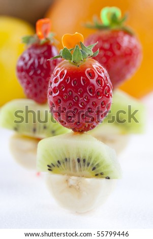 Close up of bites of fresh fruits of strawberry, banana and kiwi