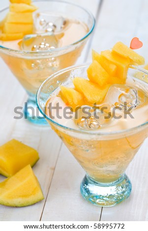 Cocktail with mango fruit on wooden table top