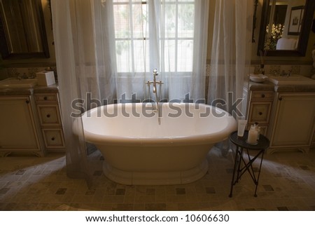 Upscale bathroom with a classic tub and tile floor.
